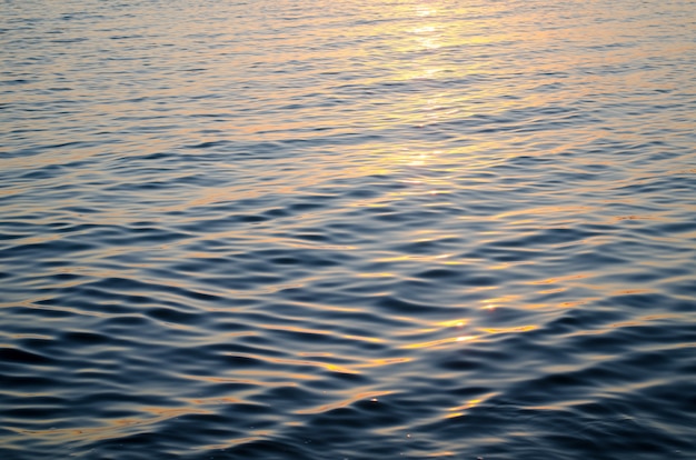 Struttura dell&#39;acqua di mare ai colori blu e arancio del tramonto, del percorso del sole