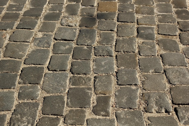 Struttura della pavimentazione in pietra Sfondo di pavimentazione in ciottoli di granito Sfondo astratto di vecchio primo piano della pavimentazione di ciottoli Texture senza cuciture