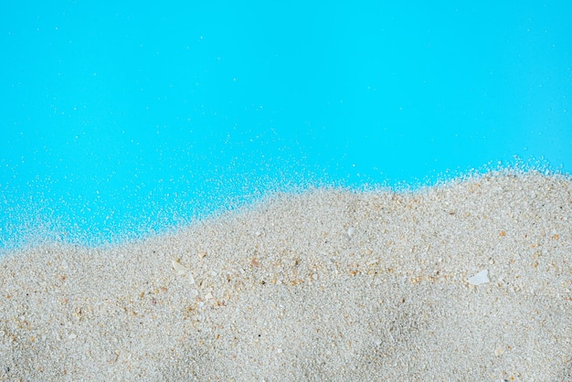 Struttura della sabbia della spiaggia del mare su sfondo blu con spazio per la copia Concetto di sfondo estivo