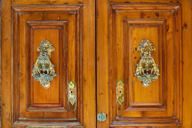 Struttura di una vecchia porta di legno di legno con maniglie di metallo insolite sull'isola di Malta