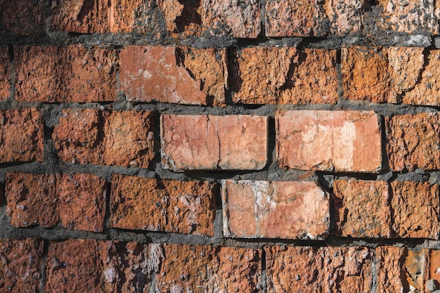 Struttura di vecchio muro di mattoni rosso incrinato e distrutto