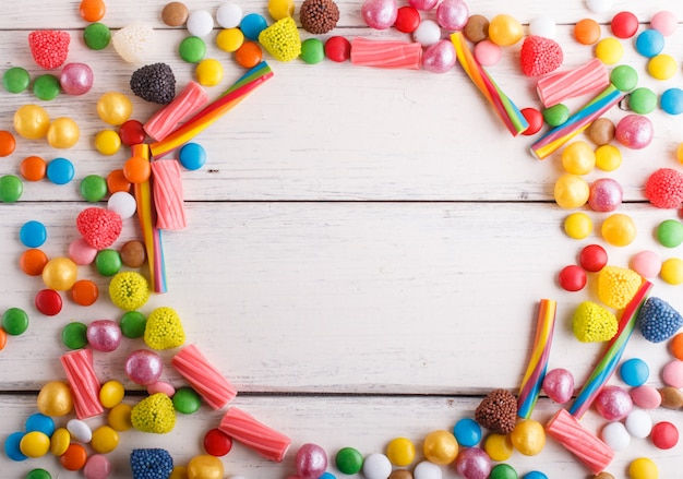 Struttura variopinta delle caramelle multicolori su di legno bianco.