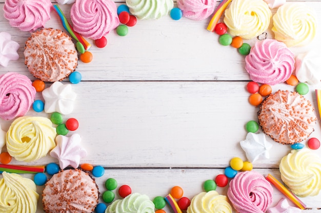 Struttura variopinta delle caramelle multicolori su di legno bianco.