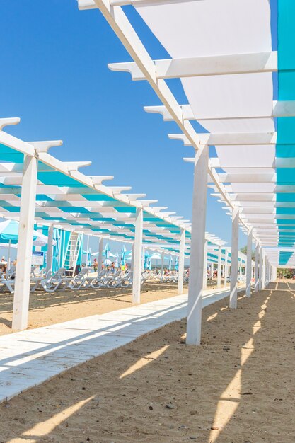 strutture architettoniche in legno e lettini bianchi sulla spiaggia del mar nero