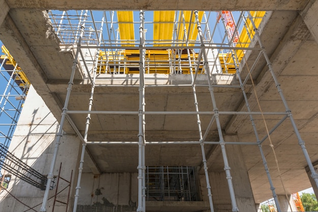 Strutture metalliche in calcestruzzo dell'edificio in costruzione. impalcature e supporti. vista dal basso