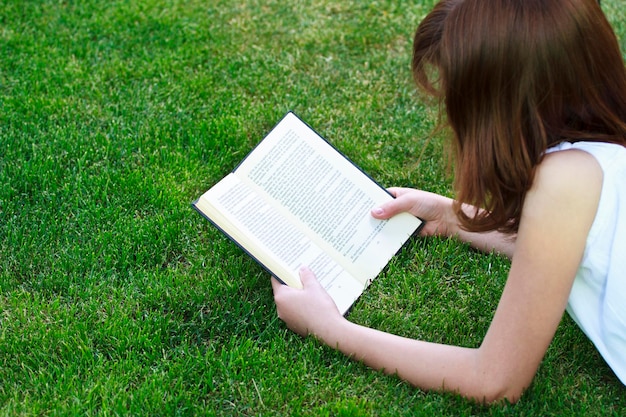 Student.Young bella ragazza che legge un libro all'aperto