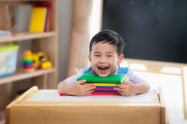 Studente asiatico felice dopo essere tornato a scuola e sorridere nella sua classe in età prescolare, questa immagine può essere utilizzata per l'educazione, lo studente, la scuola e il concetto di styd