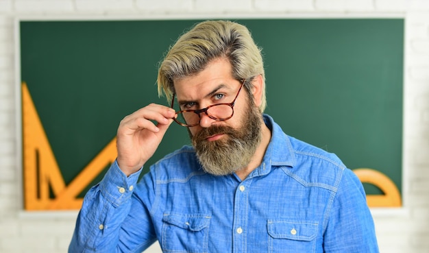 Studente barbuto nerd torna a scuola sviluppa la logica e la creatività avvia il motore del cervello ricerca fisica insegnante di matematica alla lavagna educazione scienze esatte insegnante barbuto con gli occhiali