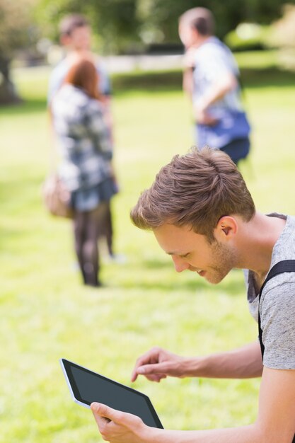 Studente bello che studia fuori nel campus