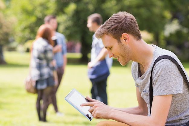 Studente bello che studia fuori nel campus