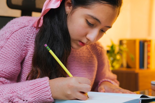 Studente caucasico millenario adolescente che fa i compiti a casa Giovane ragazza prende appunti davanti al suo laptop videochiamata da casa Scuola a casa