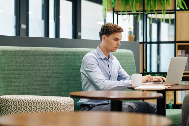 Studente che lavora al caffè laptopin