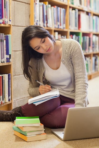 Studente che lavora al piano della biblioteca