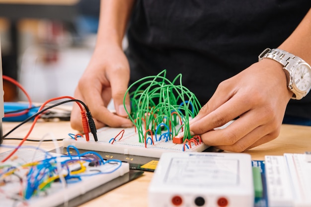 Studente che lavora su una breadboard con fili e interruttori