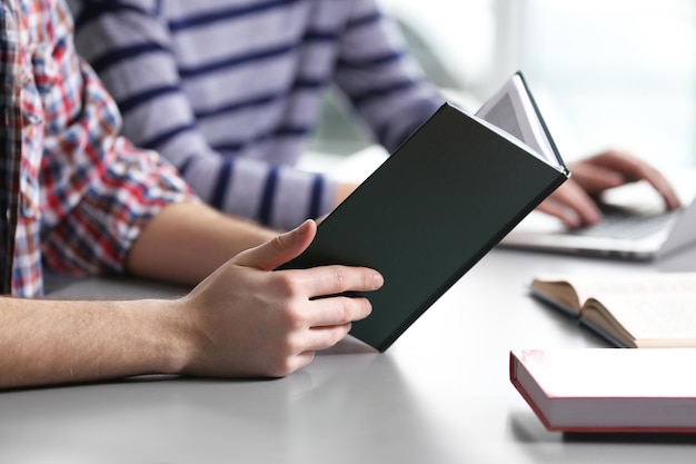 Studente che legge il libro di testo al tavolo