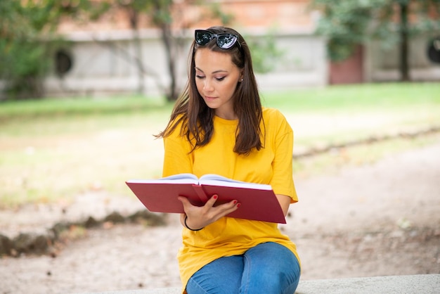 Studente che legge un libro al parco