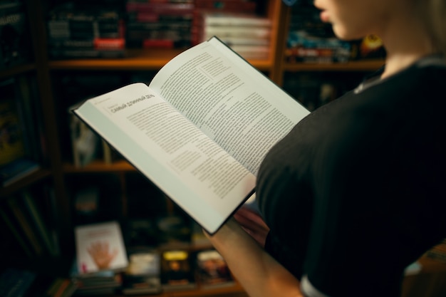 Studente che legge un libro in biblioteca