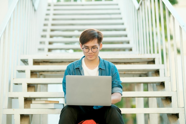 Studente che studia all'aperto utilizzando il computer portatile