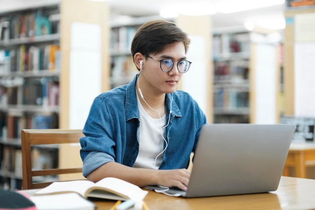 Studente che studia online in biblioteca