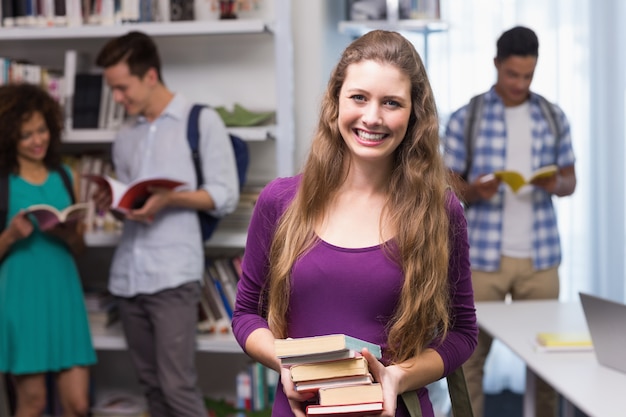 Studente che trasporta una piccola pila di libri