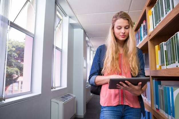 Studente che utilizza la compressa nella biblioteca