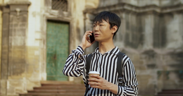 Studente cinese del tipo che parla sul cellulare