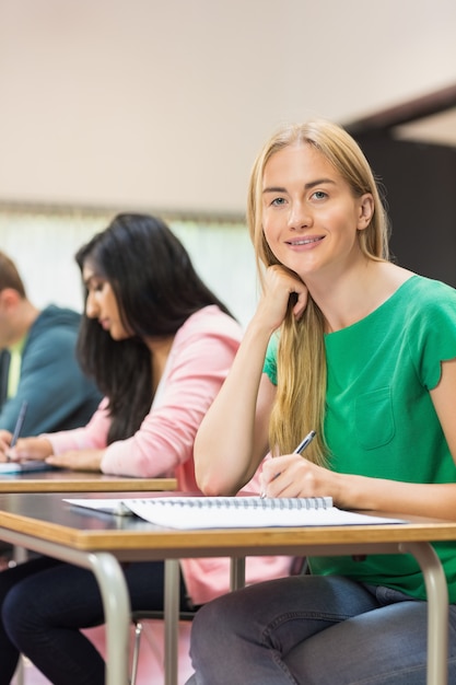 Studente con gli altri scrivere note in aula