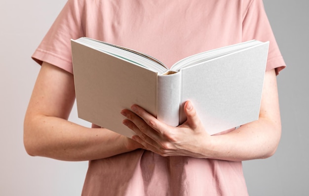 Studente con un libro bianco aperto in mano