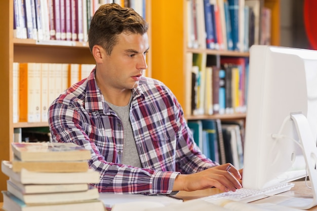 Studente concentrato bello che per mezzo del computer