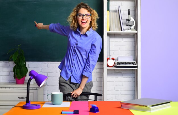 Studente della giornata mondiale degli insegnanti che studia in classe studente felice con lo sfondo della lavagna