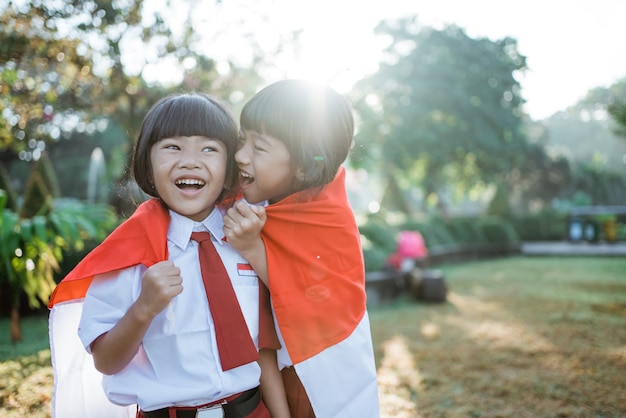 Studente della scuola indonesiana che tiene bandiera durante il giorno dell'indipendenza