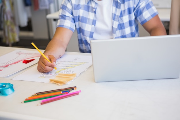 Studente di college che utilizza computer portatile mentre disegnando l&#39;immagine