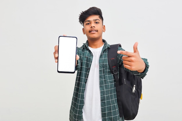 Studente di college indiano che mostra lo schermo mobile su sfondo bianco.