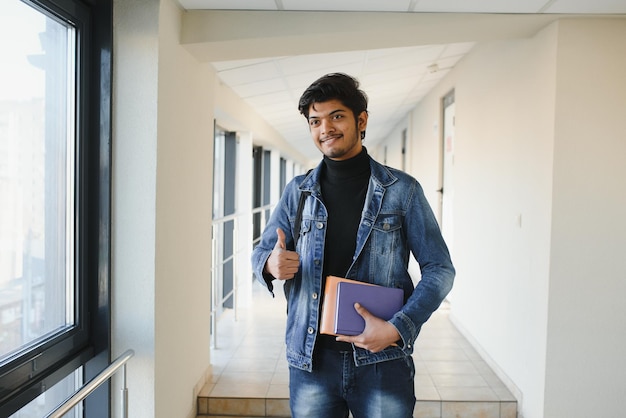 Studente di college maschio indiano bello e giovane.