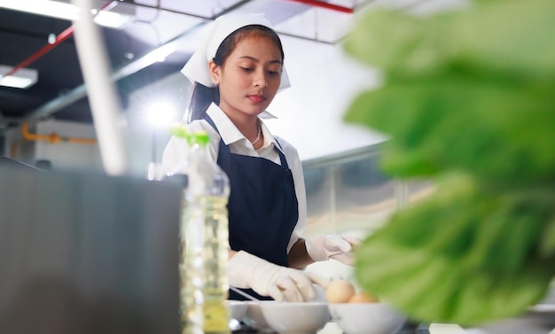 Studente di cucina della giovane donna del ritratto Aula culinaria della lezione di cucina Gli studenti multietnici della giovane donna felice si stanno concentrando sulle lezioni di cucina in una scuola di cucina