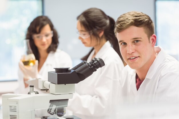 Studente di scienze che osserva tramite il microscopio in laboratorio