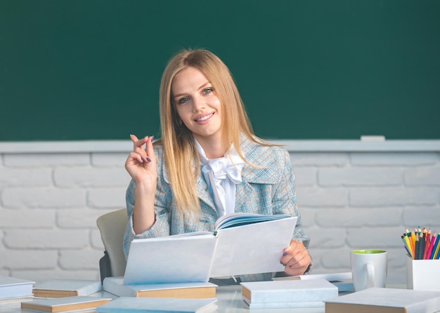 Studente di scuola superiore in possesso di un libro che impara l'inglese o la matematica in classe