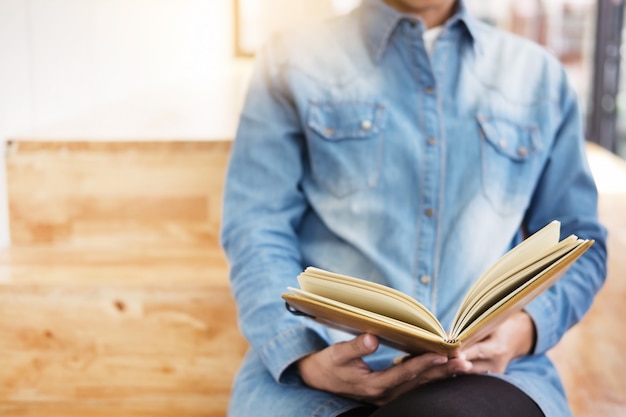 Studente di sesso femminile premuroso seduto Serio leggere un libro in un pavimento di libreria, concetto di formazione.