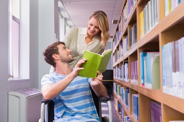 Studente disabile sorridente con il compagno di classe in biblioteca