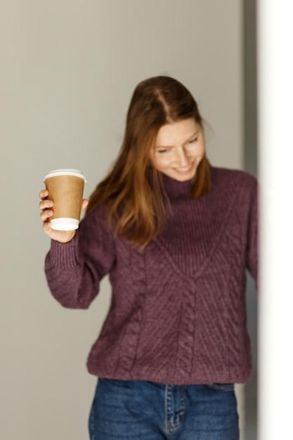 Studente felice che tiene una tazza di caffè da asporto