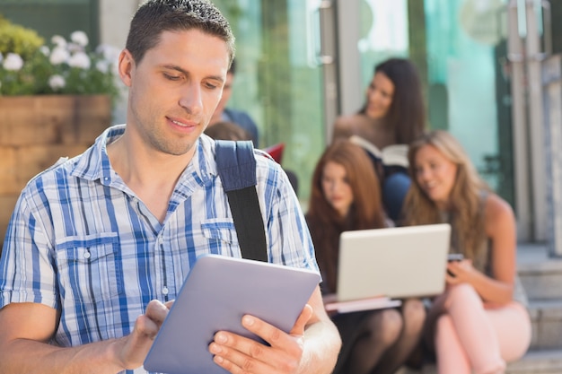 Studente felice che utilizza il suo tablet pc nel campus