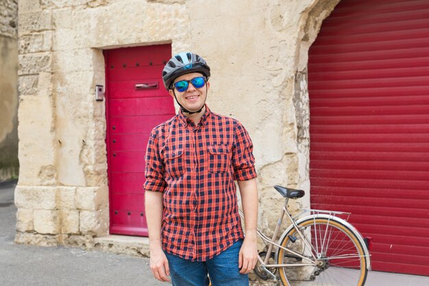 Studente felice con casco e occhiali da sole in strada