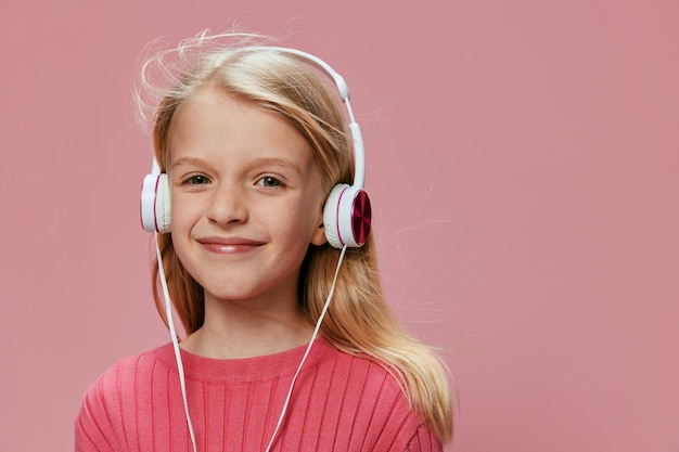Studente felice con le cuffie rosa e un'espressione a bocca aperta in uno studio elegante