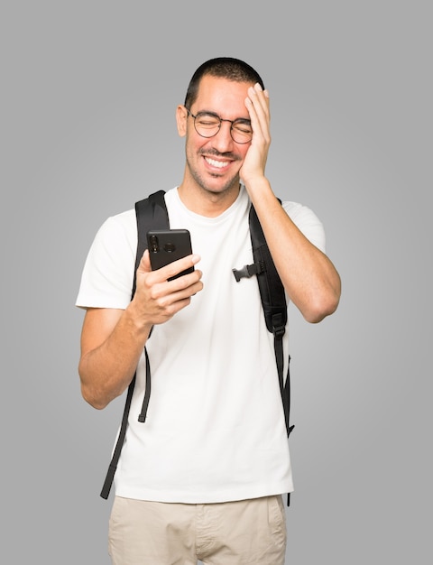 Studente felice utilizzando il suo telefono cellulare