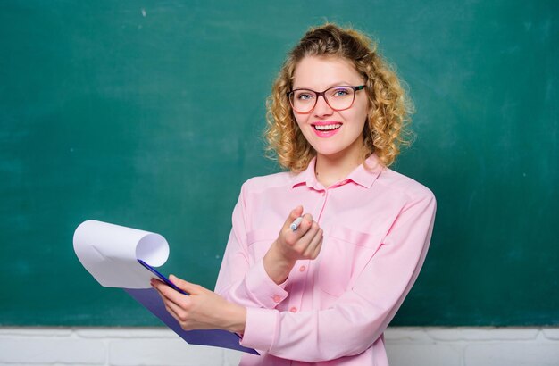 Studente fiducioso che studia ragazza insegnante alla lezione nuovo anno scolastico Ragazza prepara per gli esami insegnante con cartella documenti relazione progetto ritorno a scuola studente felice con gli occhiali alla lavagna