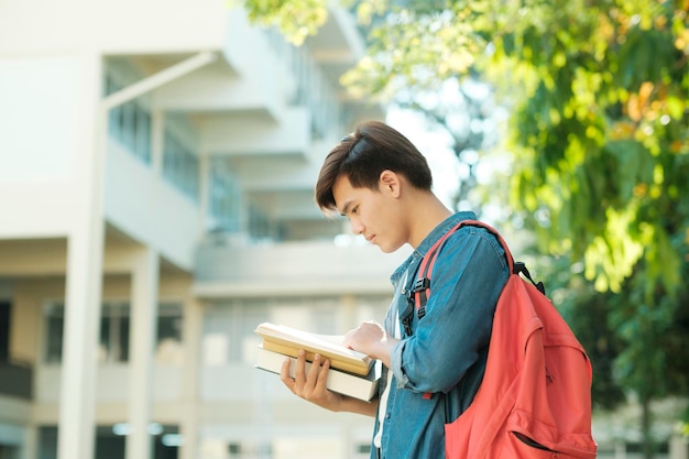 Studente in piedi all'aperto e in possesso di libri