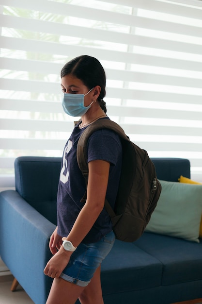 Studente ispanico che indossa la maschera prima di andare a scuola