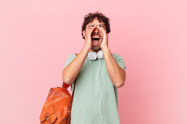 Studente ispanico che si sente felice, eccitato e positivo, gridando con le mani vicino alla bocca