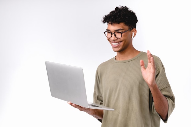 Studente maschio afro felice che fa una videochiamata su un portatile isolato su uno sfondo bianco