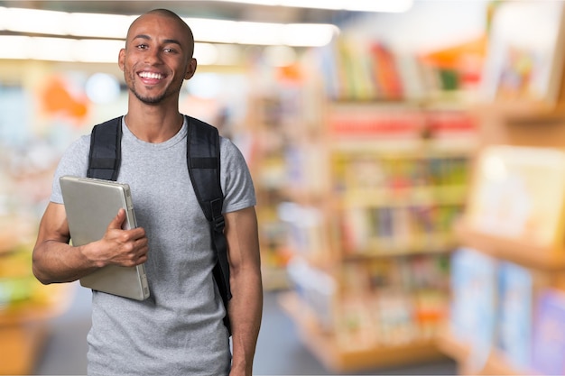 Studente maschio con lo zaino sullo sfondo